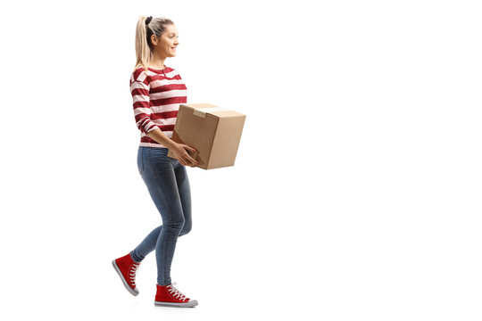 Young woman carrying a box and walking