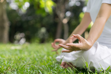 The woman yoga and meditation in the park feel relaxed and calm, happy.