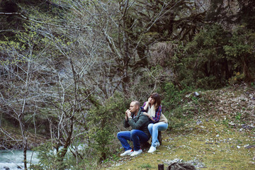 Fototapeta premium The guy plays the girl on the pipe. In the woods.