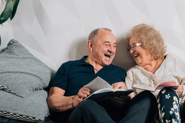 Happy senior couple laughing in bed at home.Cheerful senior woman with husband in nightwear at home.happy old age - obrazy, fototapety, plakaty