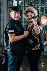 Fototapeta na wymiar Happy couple of retirees in biker clothes.Senior man in black leather jacket and goggles.Biker grandmother and biker grandfather. Biker couple.