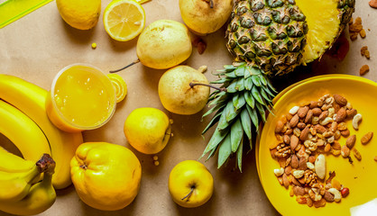 Mix of yellow fruits and nuts on cardboard background