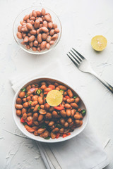 Boiled Peanut Chaat or Chatpata sing dana or shengdana or mungfali. served in a ceramic bowl over moody background