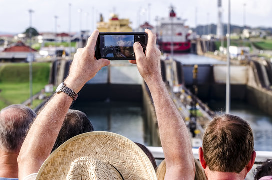 Panama - February 20, 2015: Cruise ship passengers photographing the entrance of the ships in the Panama Canal. The canal cuts across the Isthmus of Panama and is a conduit for maritime trade.