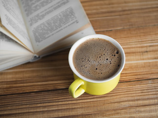 A Cup of cappuccino with a book in the cafe . vintage style