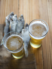 Dried fish with beer on wooden background