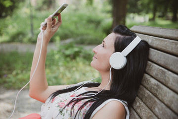 Attraktive Frau hört Musik im Park