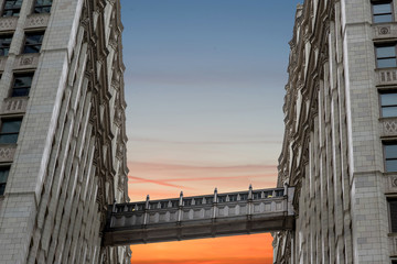 two symmetrical tall buildings opposite each other against the background of a cloudy sky. Space...