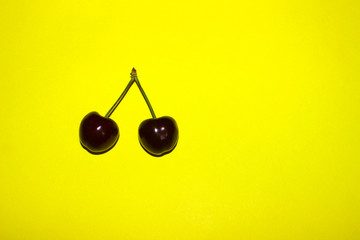 Two Berries Of Sweet Cherry On Yellow Background. Food, Summer, Colorful Background. Abstract Colorful Background. 
