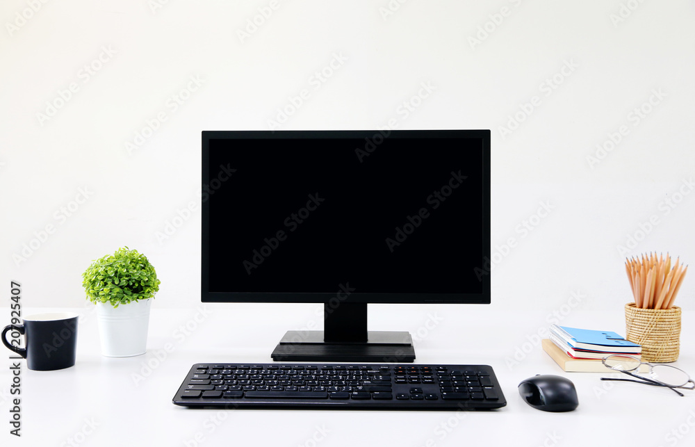 Poster front view blank screen computer with mouse, keyboard,pencils and tree vase in modern office