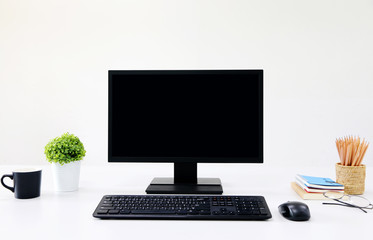 Fototapeta premium front view blank screen Computer with mouse, keyboard,pencils and tree vase in Modern office