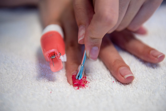 Removing nail polish with reusable plastic pinches and cotton pads soaked with acetone and nail spatula