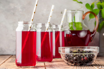 Beverage compote of red berries black currant cherries blueberries in cocktail jars