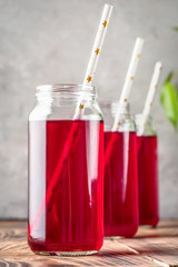Beverage compote of red berries black currant cherries blueberries in cocktail jars