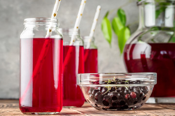 Beverage compote of red berries black currant cherries blueberries in cocktail jars