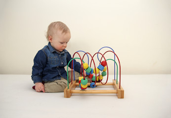 Little boy playing wooden colorful logic toy