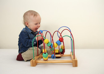 Little boy playing wooden colorful logic toy