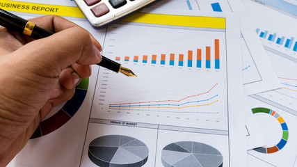 business report with pen statement with graph and data analysis