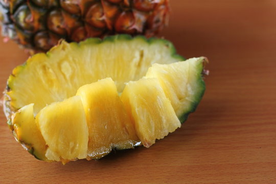 Ripe pineapple and pineapple slices on wooden