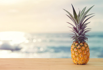 Pineapple on wooden table. Beach and tropical theme.