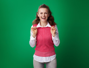 smiling young student woman isolated on green background