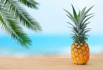 Pineapple on wooden table. Beach and tropical theme.