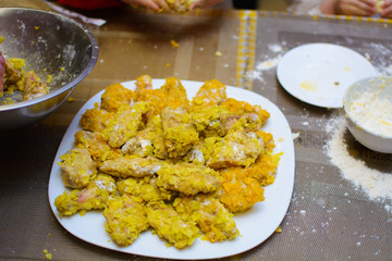 a lot of fried chicken wings in a white plate