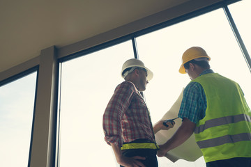 Male engineer talking with worker at a construction site.