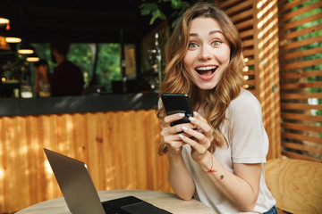 Portrait of a happy young girl holding mobile phone