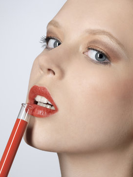 Woman With A Test Tube Full Of Orange Lip Gloss