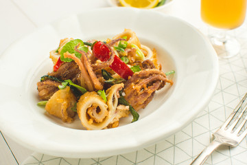 Fried Squids Tentacle, Chili Pepper and Mint Leaves on White Plate