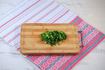 Greens fresh on a wooden board on a table. Parsley, fennel.