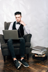 Businessman working on laptop computer at coworking office. Coworking open space.Attractive man in suit is using a laptop for work.