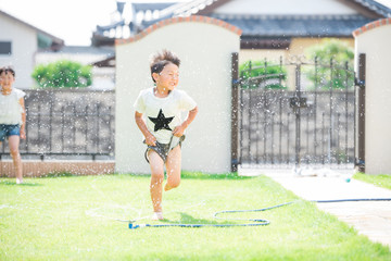 庭で水遊びをする男の子