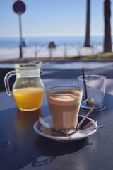 Healthy breakfast with coffee and orange juice in a cafe with a sea view