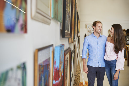 Couple Looking At Paintings In Art Gallery Together