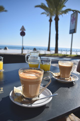 Healthy breakfast with coffee and orange juice in a cafe with a sea view