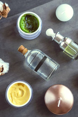 SPA cosmetic products on dark table from above. Coconut, argan oils, organic creams and serums....