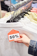 Hand hält Preisschild mit 50% Rabatt