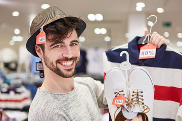 Glücklicher junger Mann beim Shopping