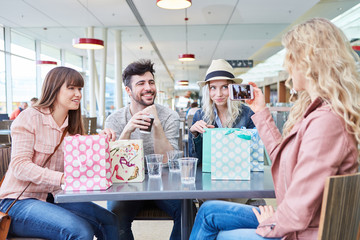 Frau fotografiert ihre Freunde mit Smartphone