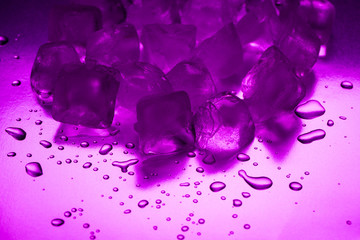 A pile of ice cubes in purple on a reflecting table
