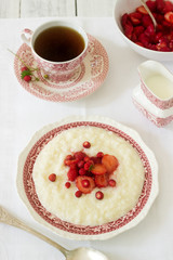 A useful breakfast of rice porridge with strawberry sauce served with tea.