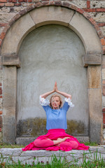 Portrait of beautiful mature woman practicing yoga and meditation,  with her palms together, outdoor. Longevity concept