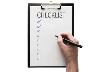 top view of hand with a pen on clipboard with checklist on white background