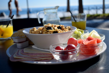 Desayuno saludable con frutas y cereales con yogur y miel en una cafetería con vista al mar