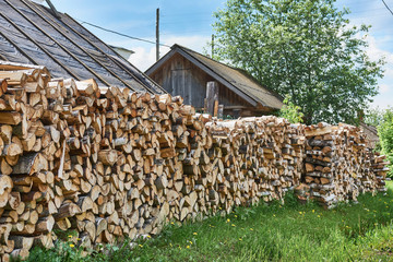 Pile of chopped birch firewood for the furnace in village.