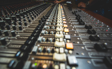Hand of the mixing engineer on the audio console