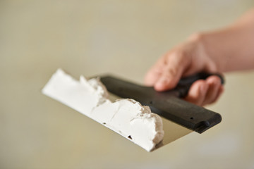 Spatula with putty in hand. Close-up.