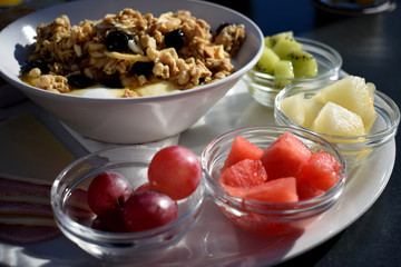 Desayuno saludable con frutas y cereales con yogur y miel en una cafetería con vista al mar